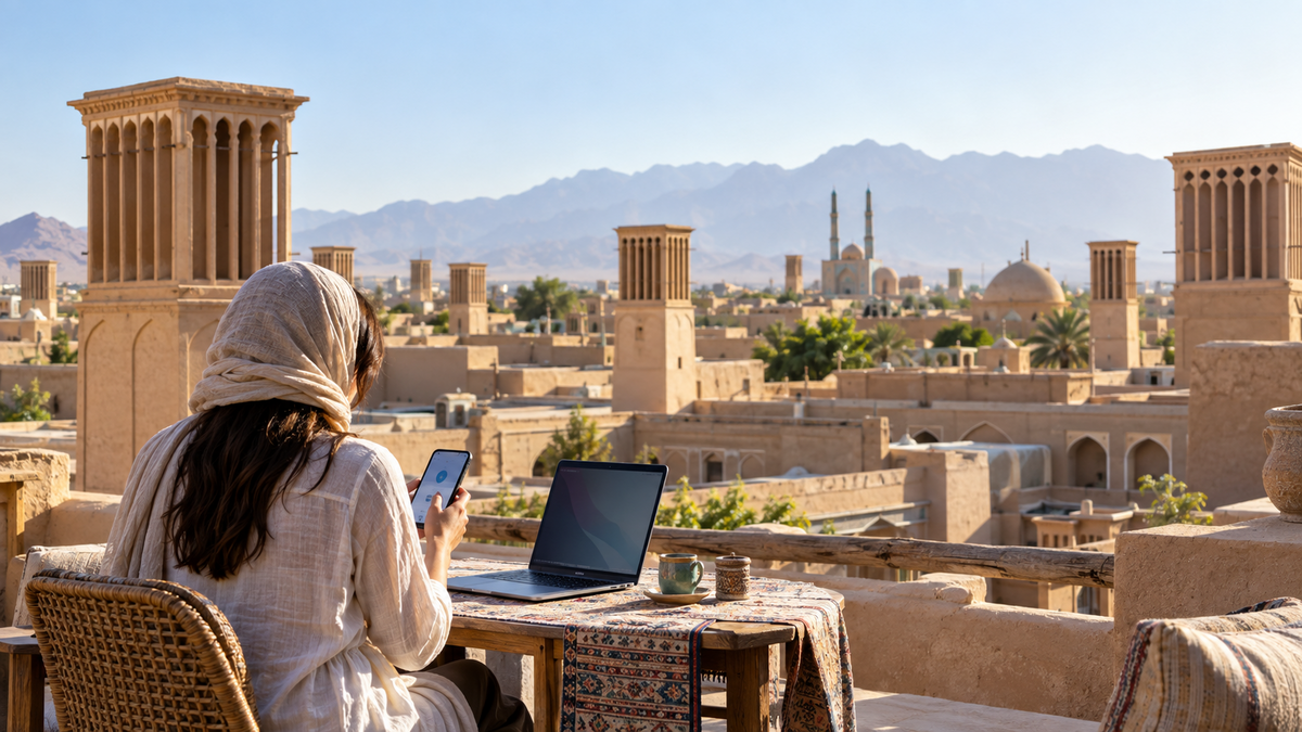 Traveler using a phone and laptop in Yazd for the Iran eSIM setup guide